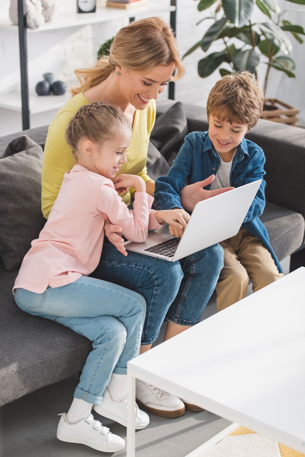 woman girl and boy looking at laptop